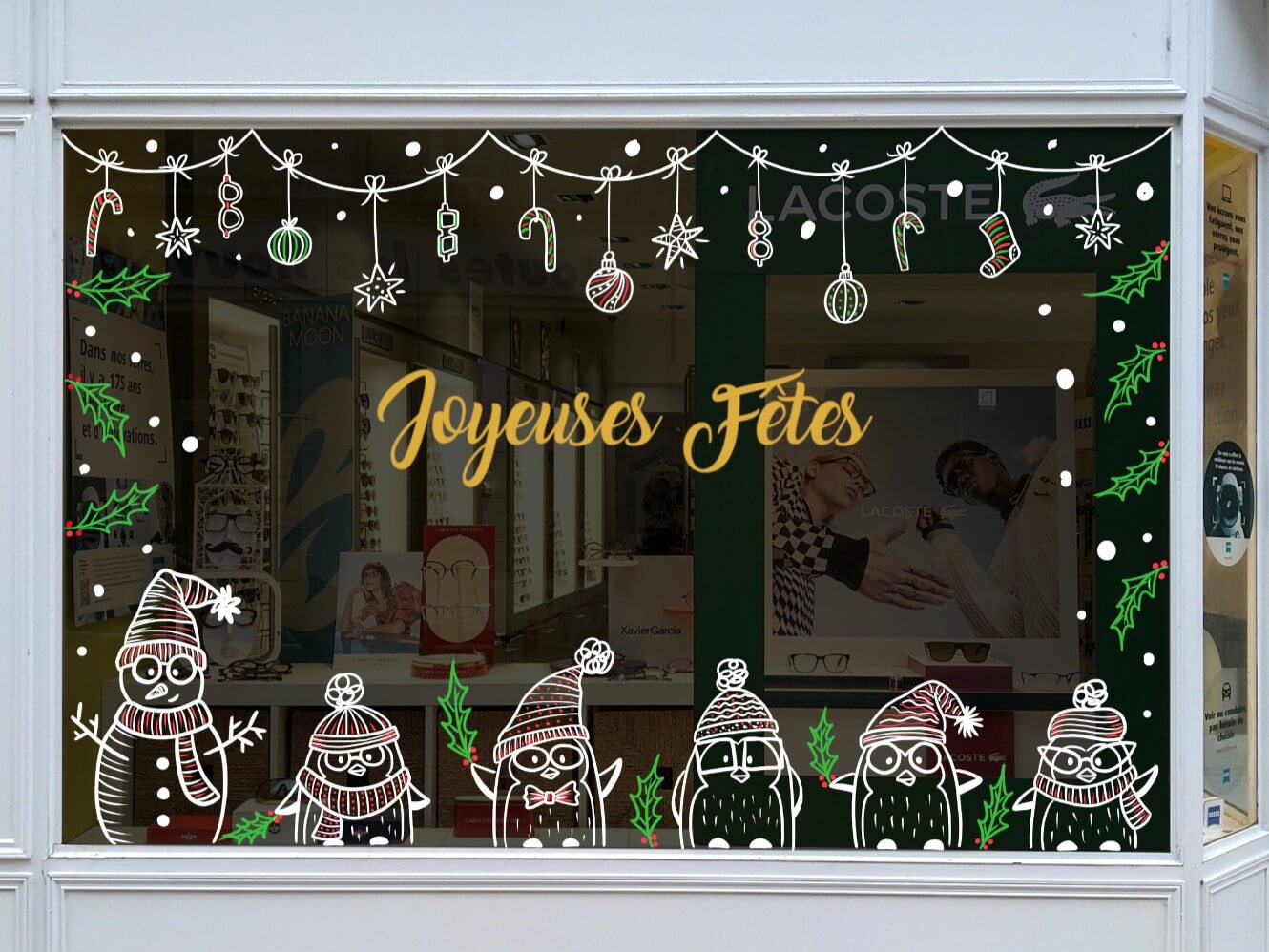 Vitrine de Noël pour un opticien à Rambouillet, avec des pingouins, des bonsommes de neige et des guirlandes par Camille Fauquet