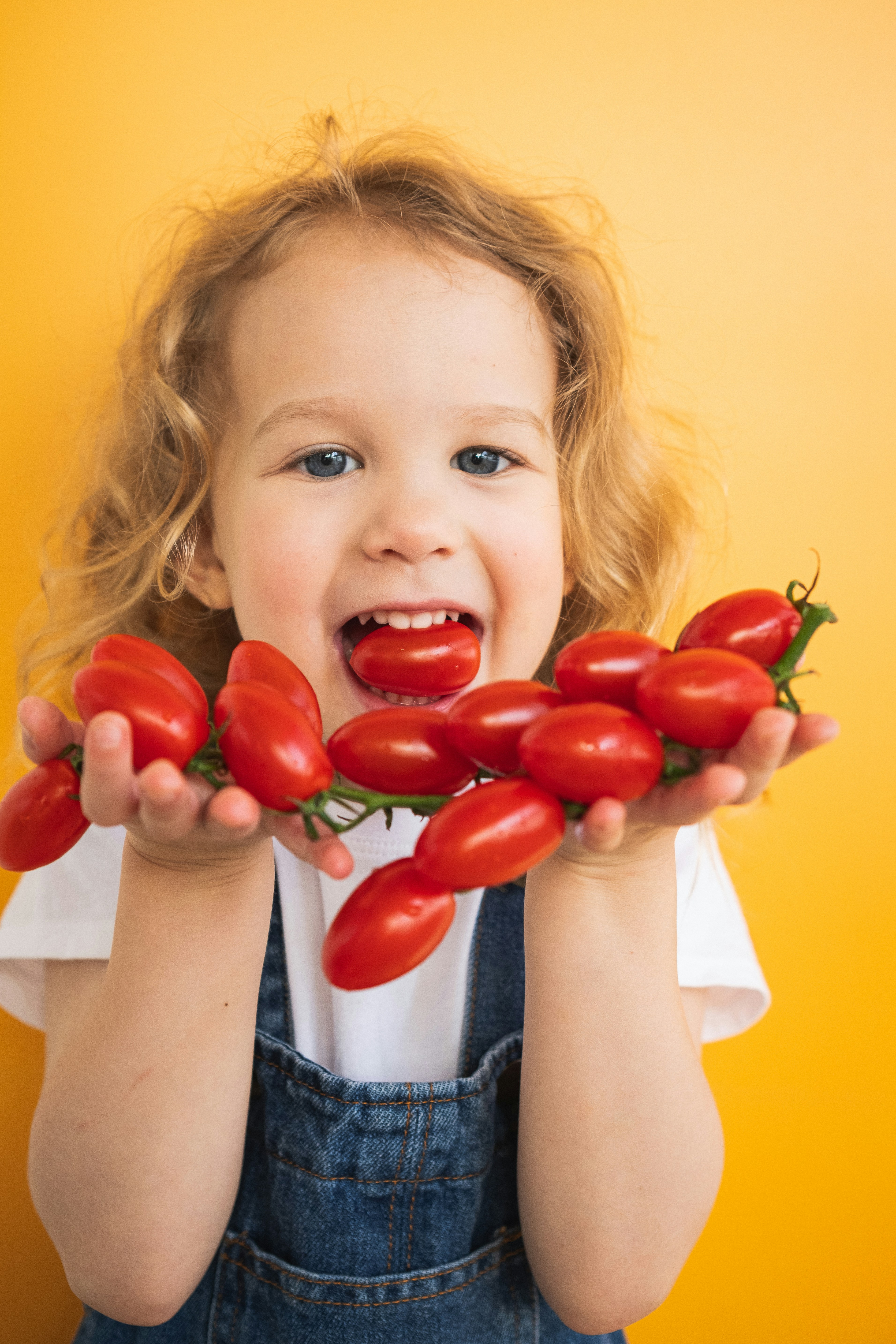 Petite-fille-tomate-dans-la-bouche