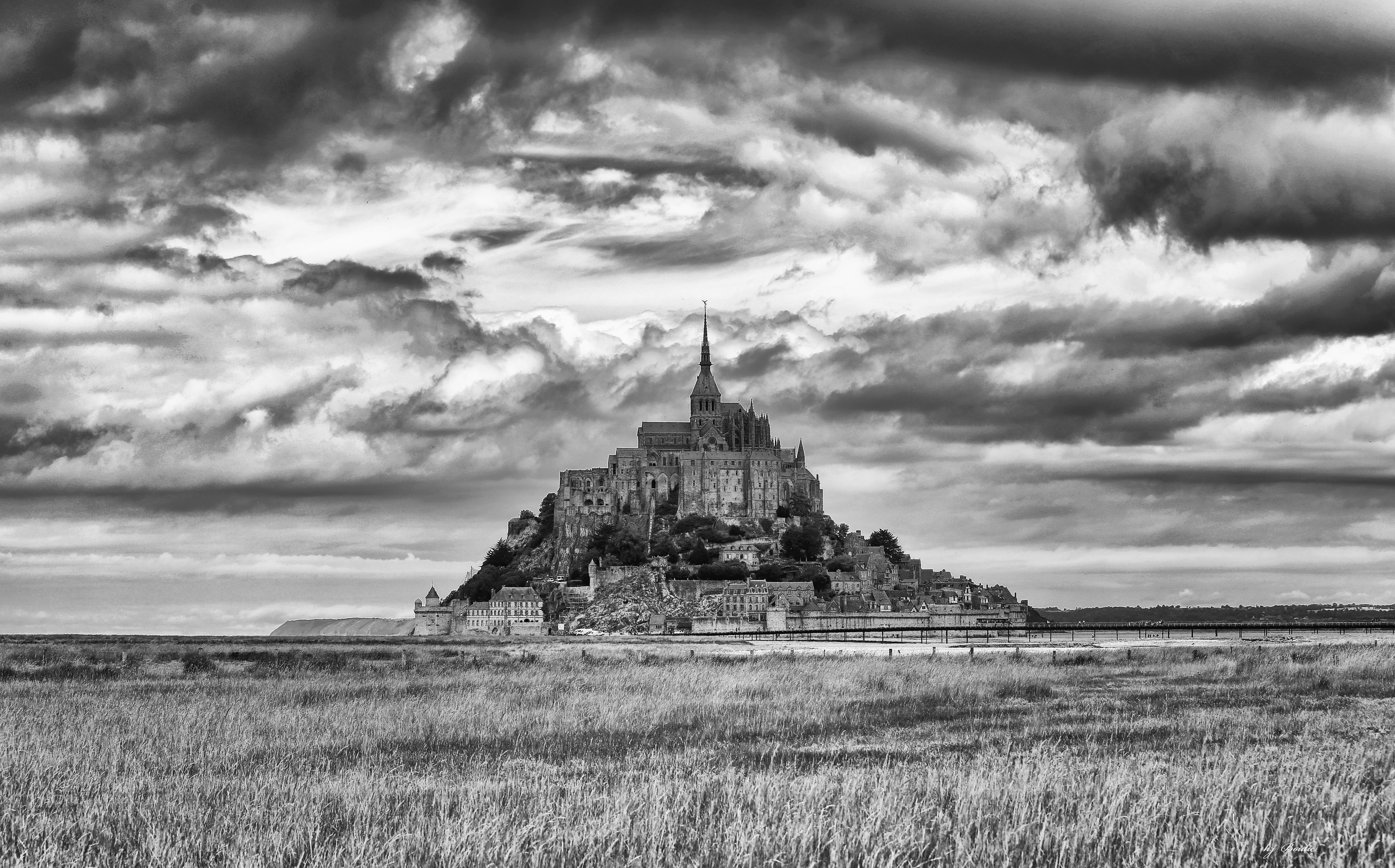 Mont Saint-Michel avec nuages au dessus en noir et blanc
crédit photo Henri Boulic