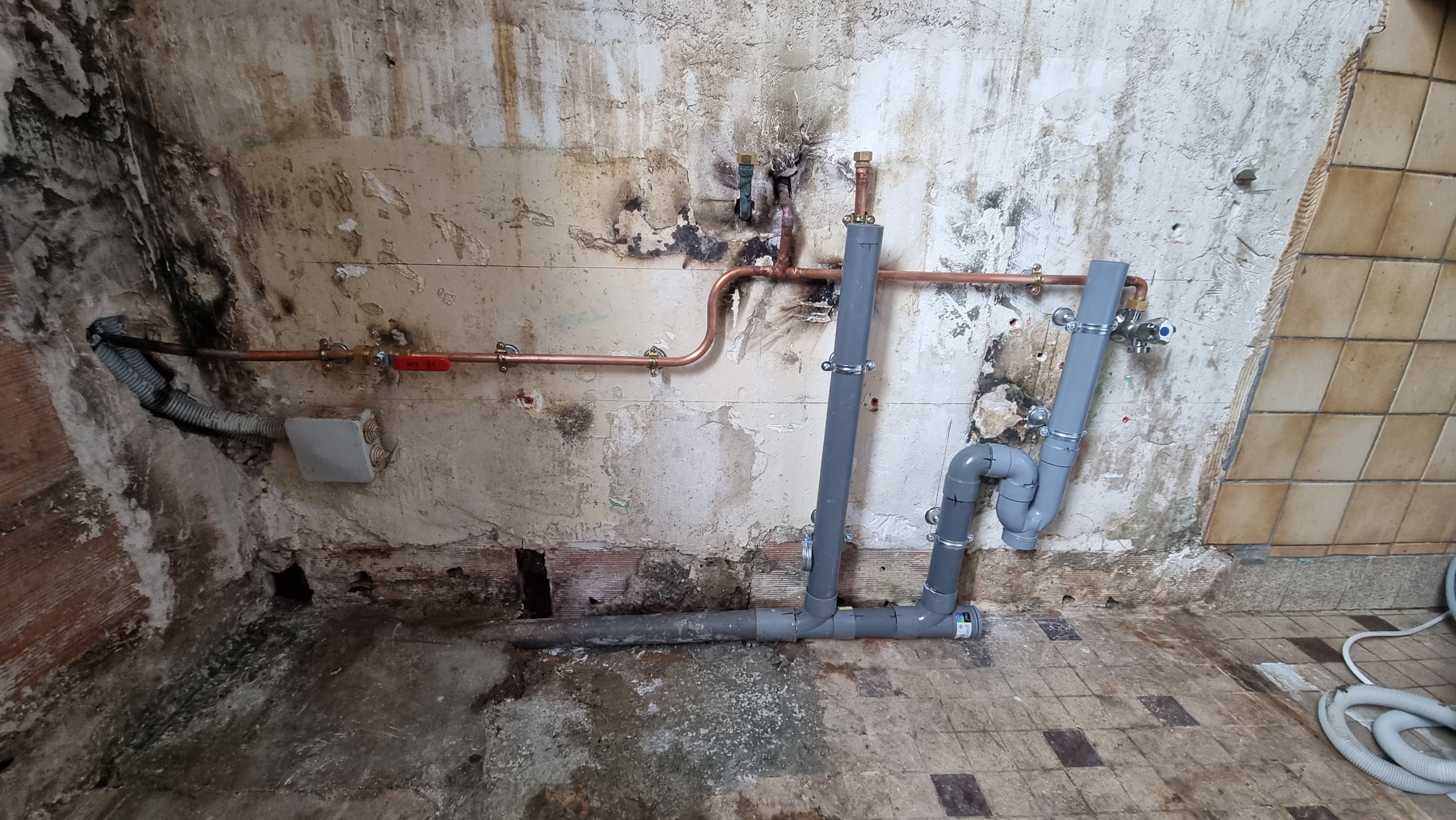 Rénovation d'une cuisine. La tuyauterie et l'installation est relativement agées. Remplacement du tube en cuivre, d'une vanne d'arrêt et de l'évacuation. Pose d'un meuble sous-évier, de l'évier, d'un mitigeur et de la faïence. 