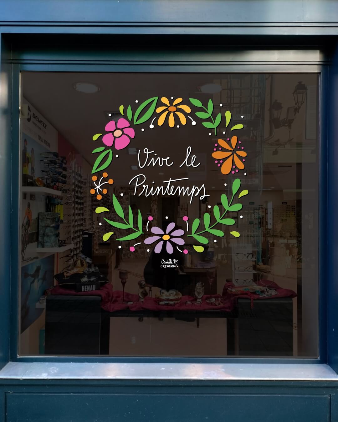 Peinture sur vitrine à Paris ou dans les Yvelines pour le Printemps, couronne végétale fleurie avec message "vive le printemps"