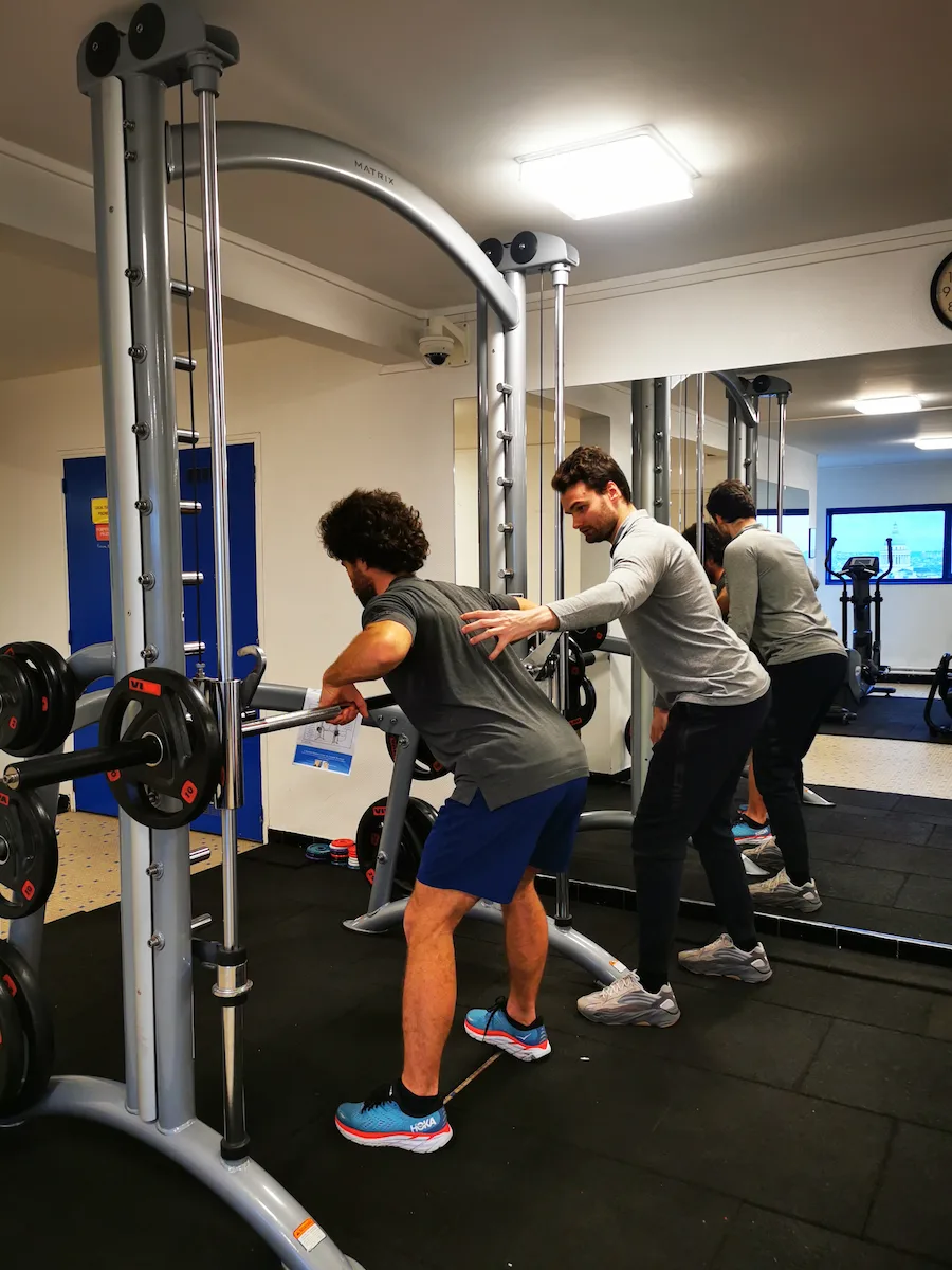 Coaching sportif personnalisé Paris 7 — Alexis Glomeron corrige la posture d'un client lors d'un exercice de rowing