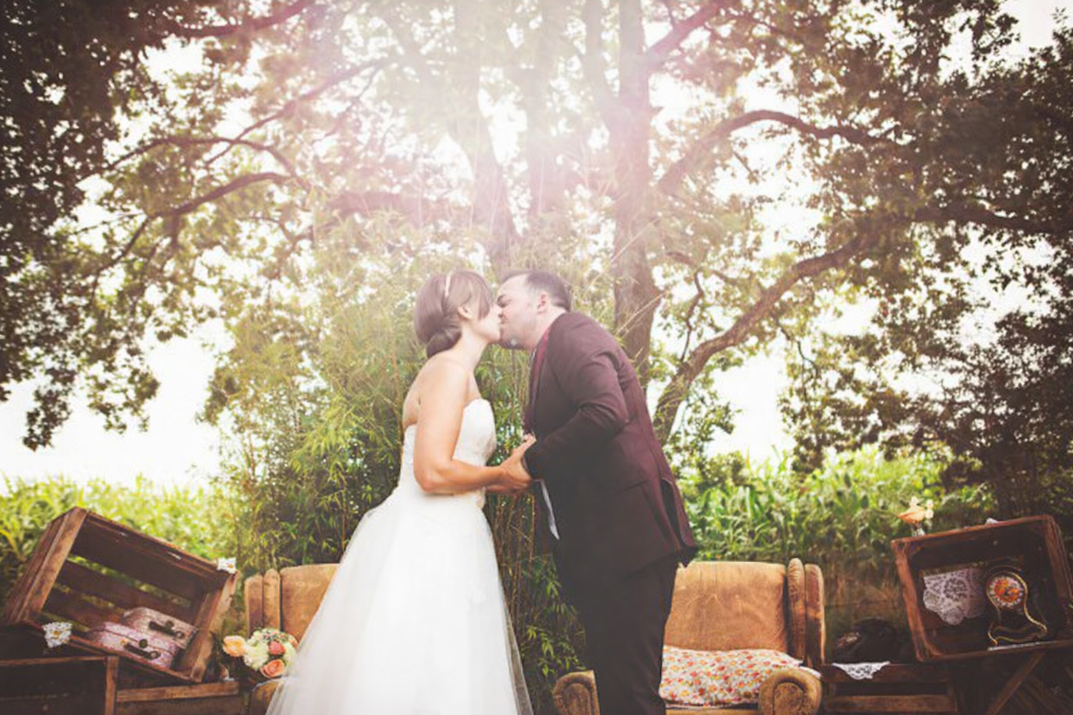 Couple de mariés sous un grand arbre dans un décor naturel du domaine