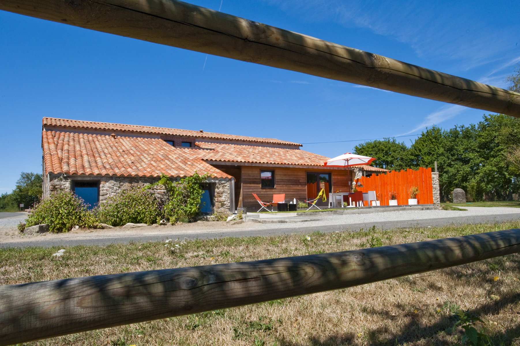 Façade en pierre avec terrasse colorée dans le cadre du domaine