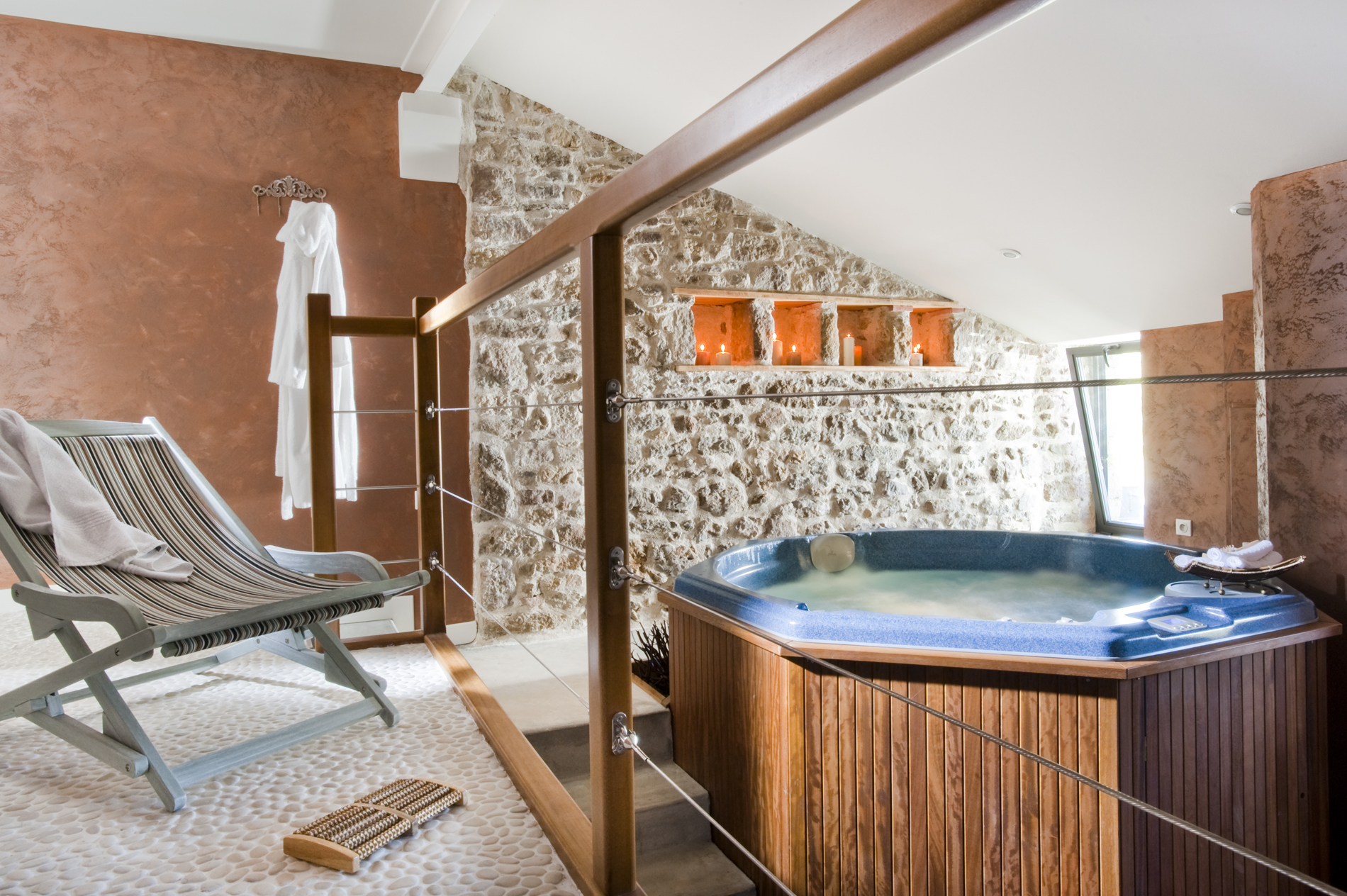 Espace bien-être avec spa et murs en pierre du domaine