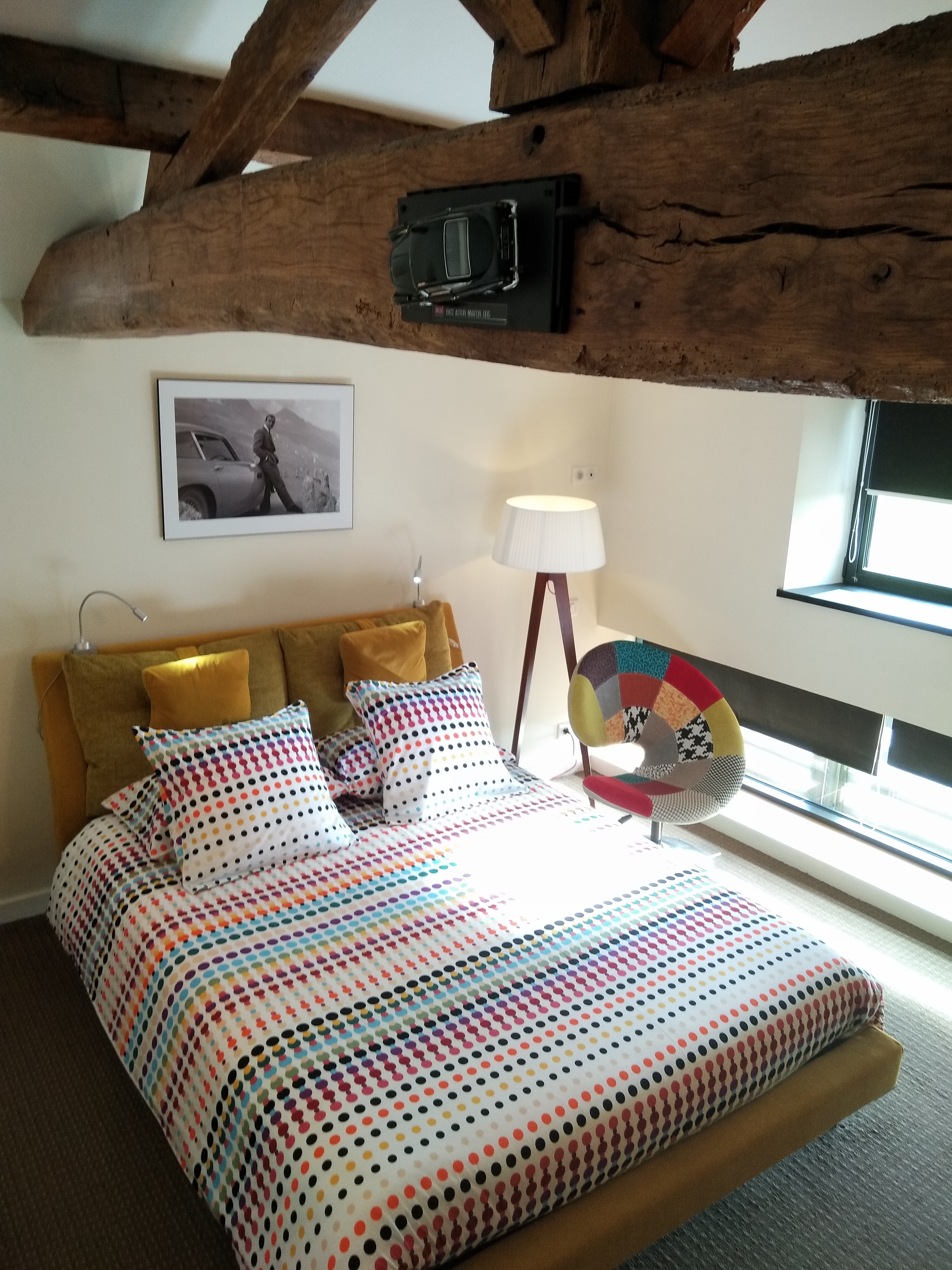 Chambre moderne mêlant poutre ancienne et couleurs vives au domaine