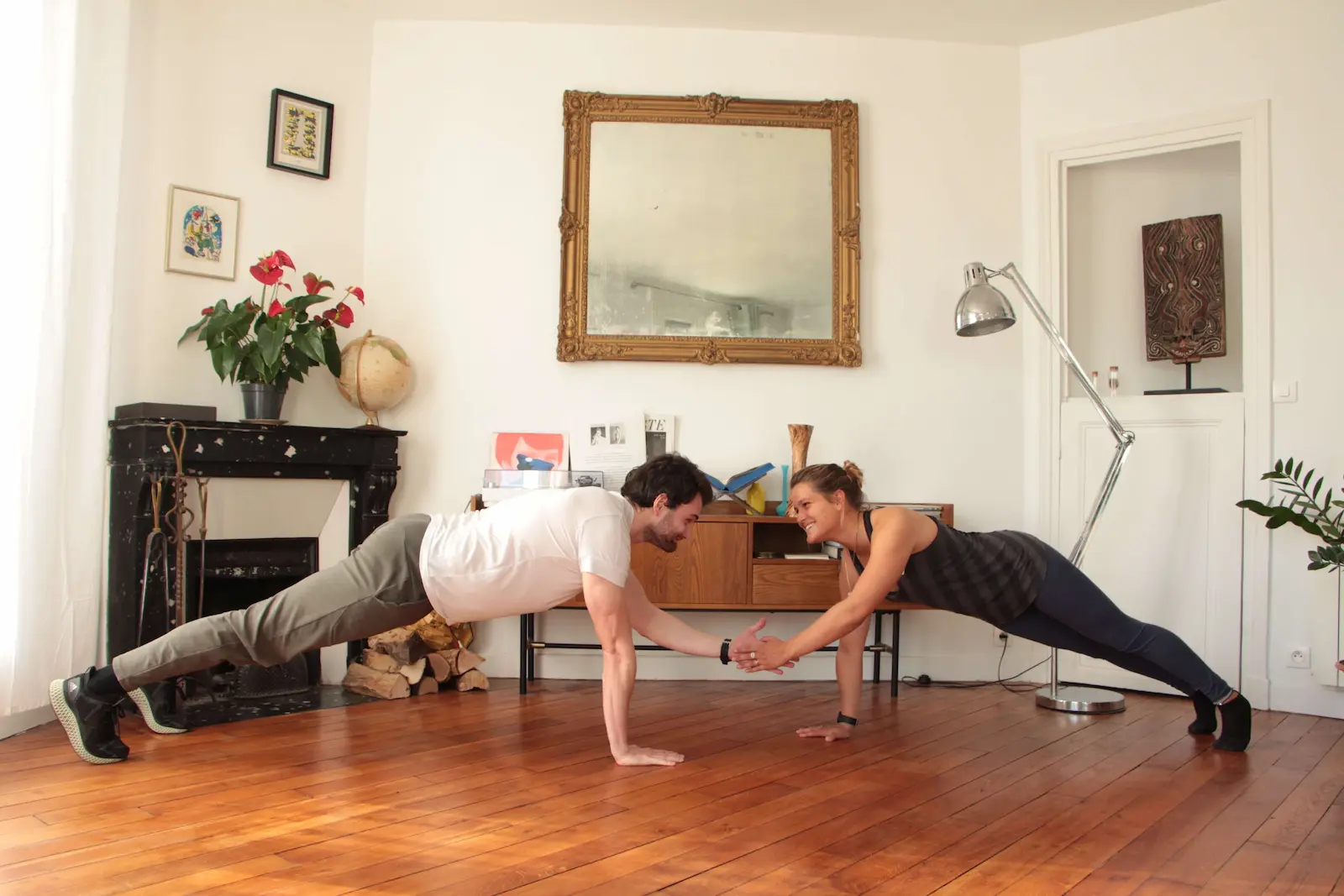 Coach sportif à domicile à Paris : séance de gainage en couple dans un salon parisien avec Alexis Glomeron