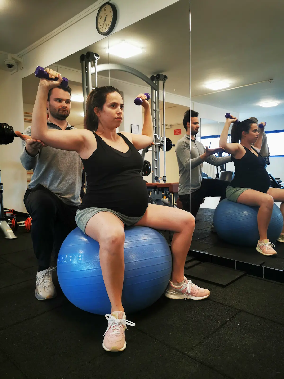 Coach sportif spécialisé grossesse à Paris — Alexis Glomeron supervise une cliente enceinte lors d'un renforcement contrôlé des épaules sur Swiss ball
