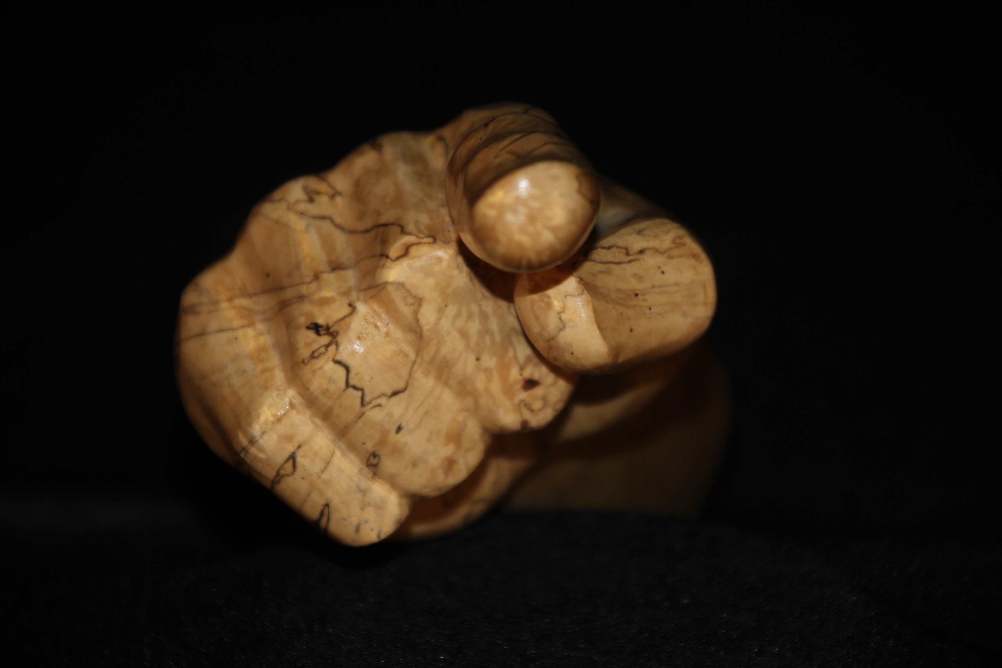 Sculpture Le Doigt levé : Sculpture d'une main au doigt levé en bois de bouleau échauffé, finition vernis transparent