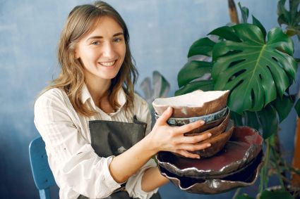 Canva cheerful female artisan with handmade ceramic dishware