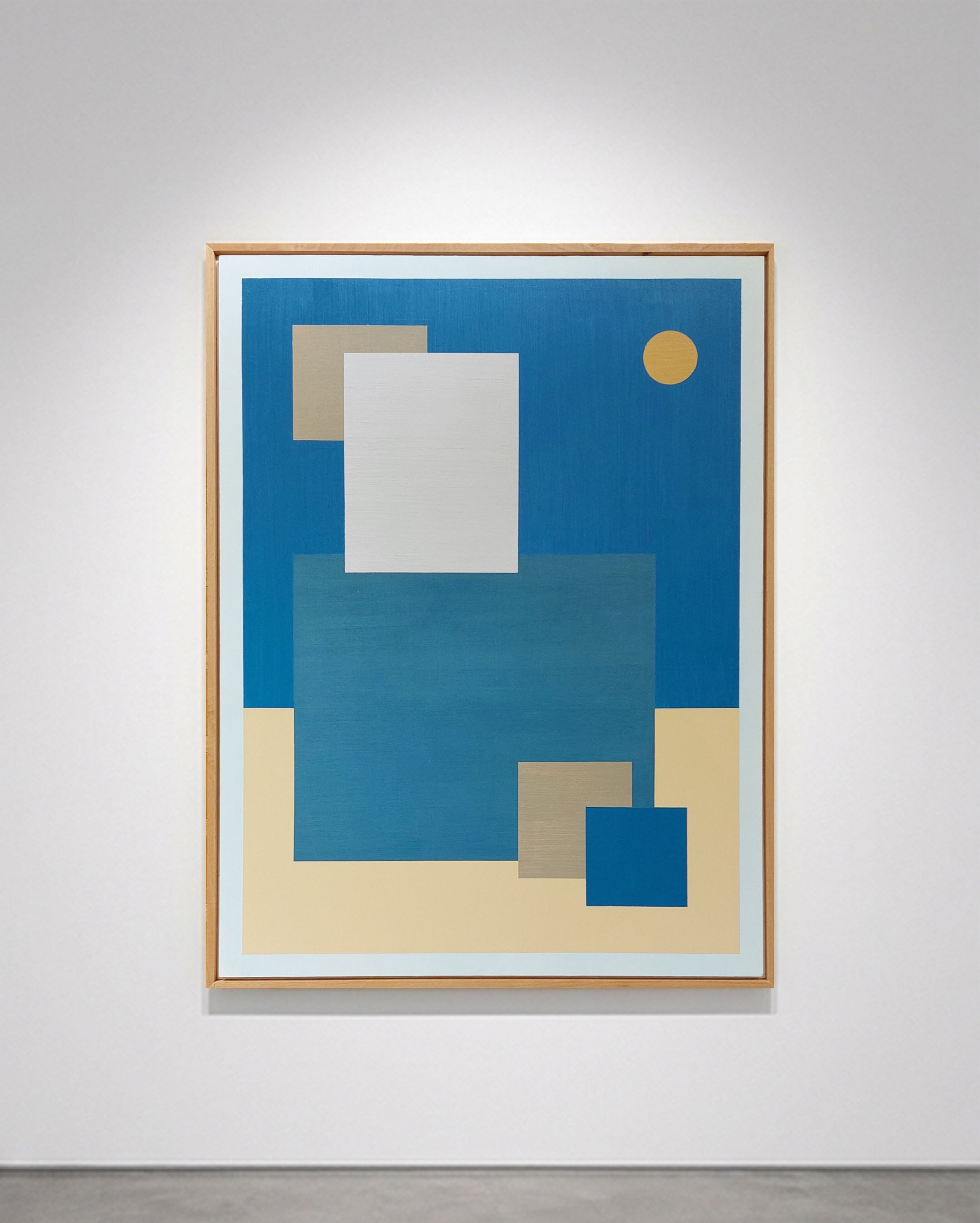Tableau rectangulaire abstrait géométrique encadré bois, Astralis par SELESTICA. Composition bicolore bleu et ocre avec des formes rectangulaires superposées turquoise, bleu, blanc, et un cercle ocre jaune évoquant un astre, accroché sur un mur de galerie blanc avec éclairage ciblé.
