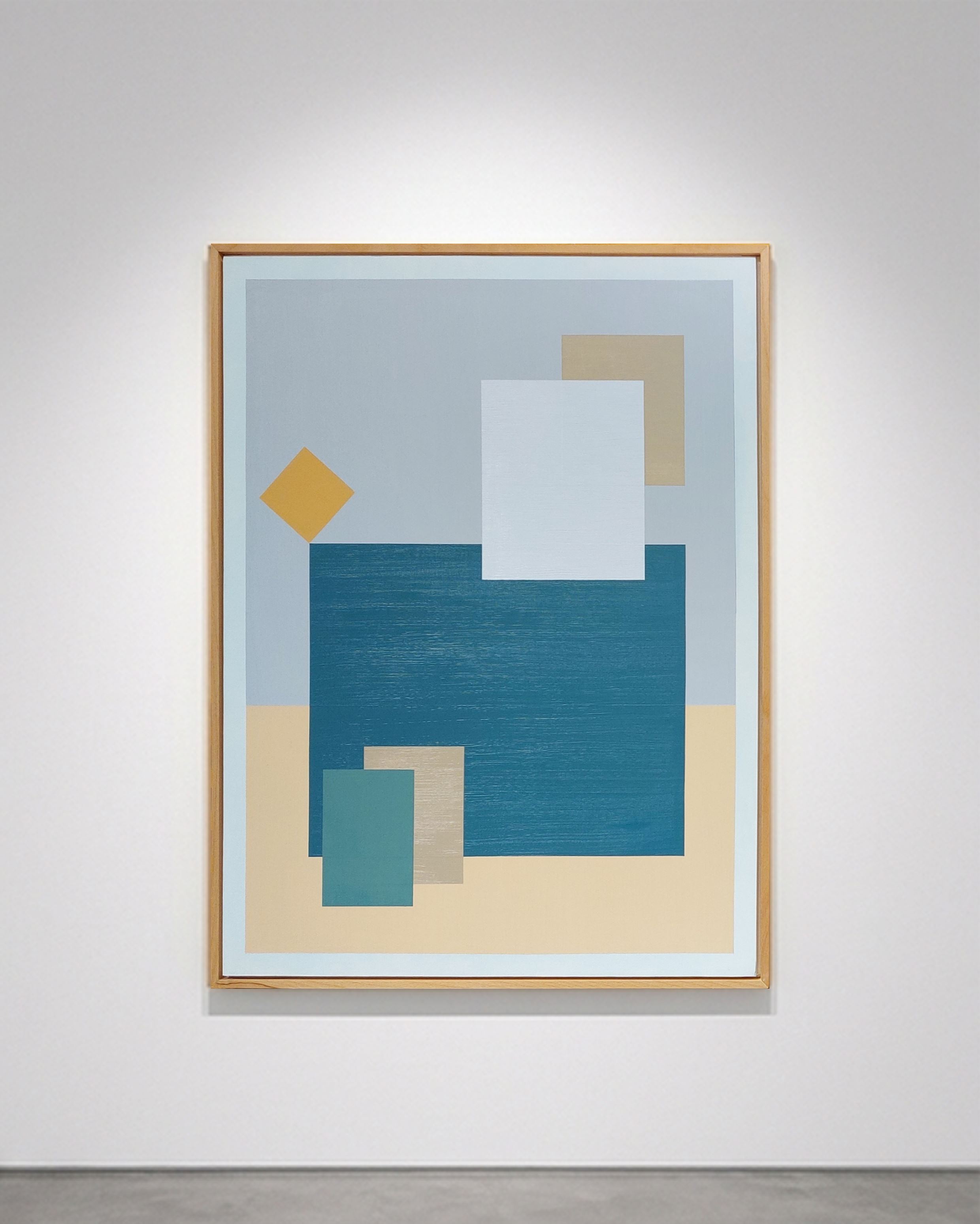 Tableau rectangulaire abstrait géométrique encadré bois, Asphalès par SELESTICA. Composition bicolore gris et ocre avec des formes rectangulaires superposées turquoise, gris et blanc, et un losange ocre jaune en équilibre, accroché sur un mur de galerie blanc avec éclairage ciblé.
