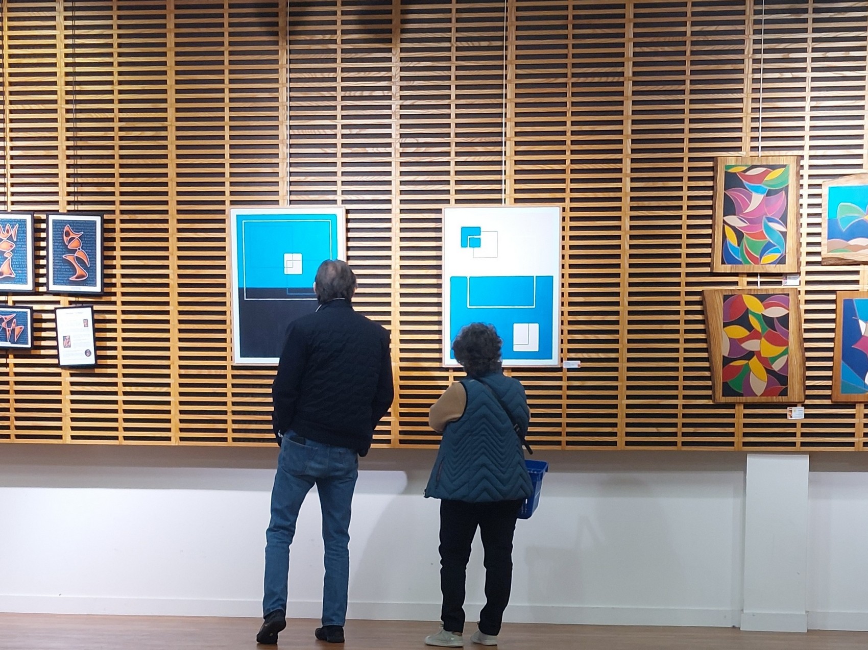 Visiteurs admirant les créations de David Vereecken dans une galerie d'art.

