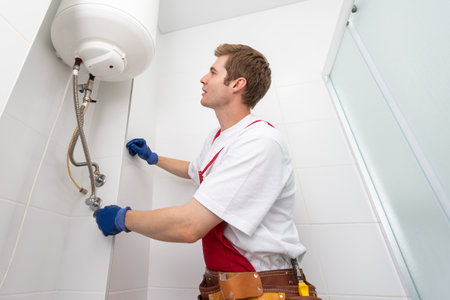 213840009 closeup of plumber using screwdriver while fixing boiler or water heater working on heating system 1 