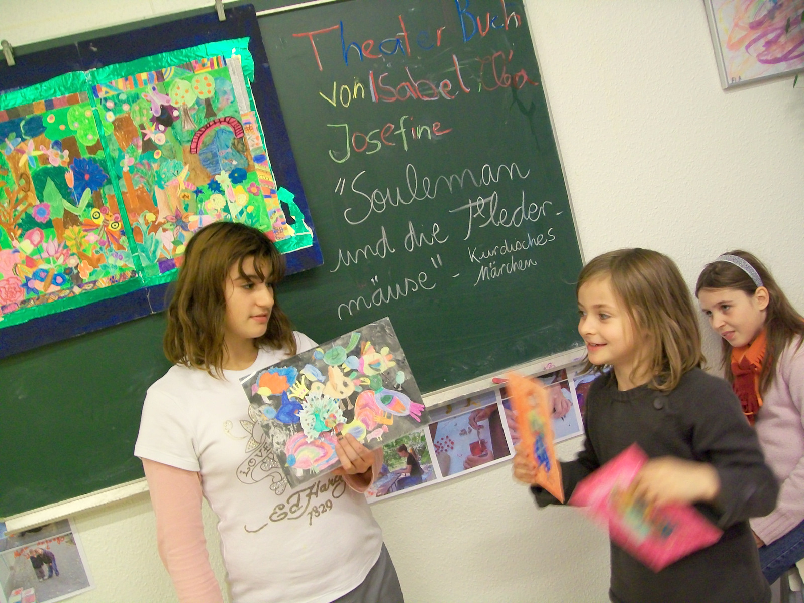 Isabel, Clea und Josi spielen mit dem Theater-Kunst-Buch das kurdische Märchen: "Suleman und die Fledermäuse". 