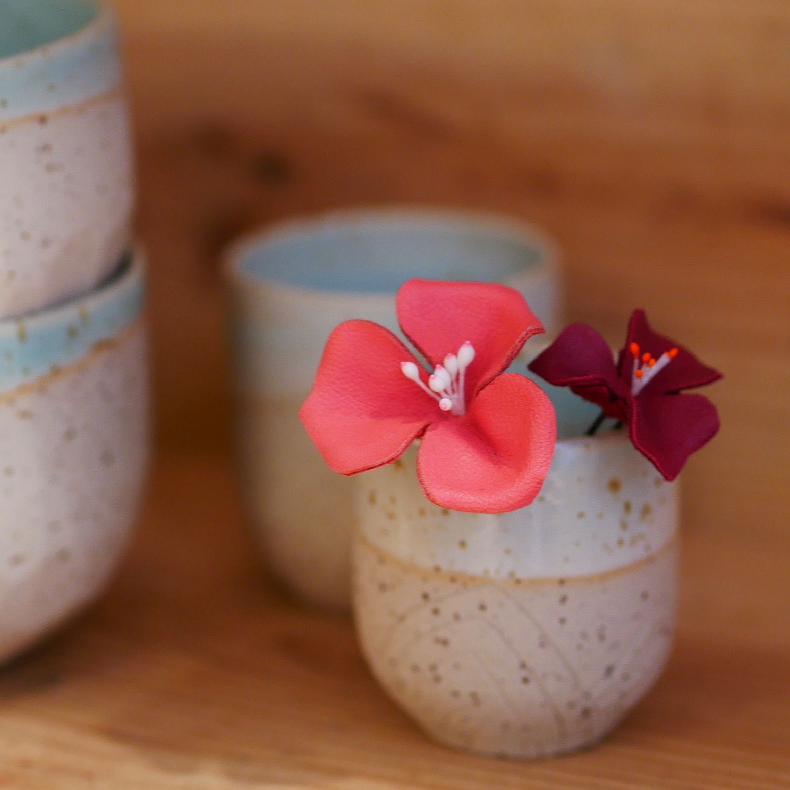 Epingles à cheveux fleur en cuir Fabriqué à Grenoble par Atelier têt'en l'air. Tasse en céramique du Chant de l'émail fabriqué dans le Trièves.