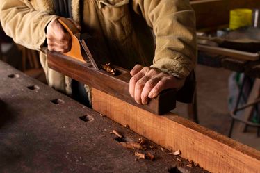 Carpenter-working-on-woodworking-side-view
