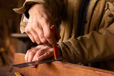 Handyman-making-pencil-line-on-wood